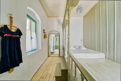 a large room with a bed and a mirror at Petridi House in Symi