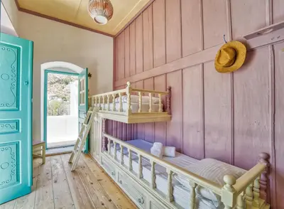 a bedroom with a bunk bed in a room with pink walls at Petridi House in Symi