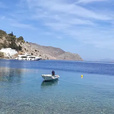 a small boat in the middle of a body of water at Petridi House in Symi