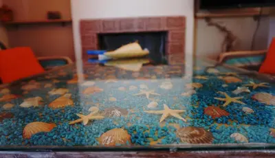 a table with shells and stars on it with a fireplace at The Blue Leaf Family Villa in Gennadi