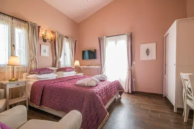 a bedroom with a bed with a red bedspread at Symi Nautilus Luxury Suites in Symi