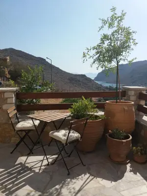 a patio with a table and chairs and a bench at Symi Nautilus Luxury Suites in Symi
