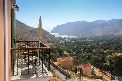 a balcony of a house with a view of a valley at Symi Nautilus Luxury Suites in Symi