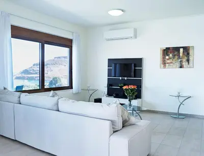 a white living room with a white couch and a window at Luxury Villa Verna in Líndos