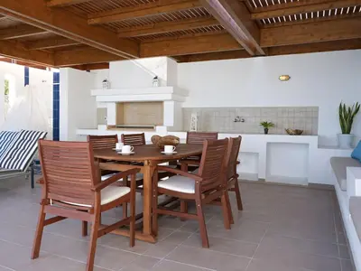 a kitchen and dining room with a wooden table and chairs at Luxury Villa Verna in Líndos