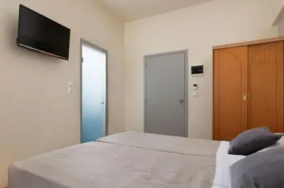 a bedroom with a bed and a television on a wall at City Plus Rhodes Hotel in Rhodes Town