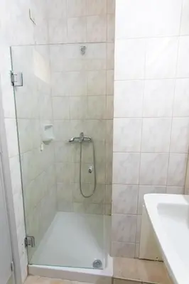 a shower with a glass door next to a sink at City Plus Rhodes Hotel in Rhodes Town