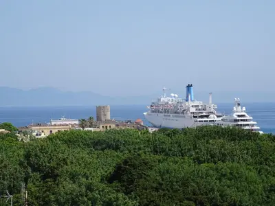 two cruise ships are docked in a harbor at City Plus Rhodes Hotel in Rhodes Town