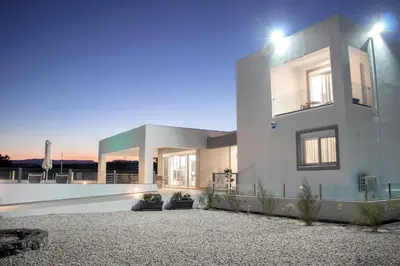 a large white house with lights on top of it at Aegean Horizon Beachfront Villas in Gennadi