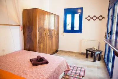 a bedroom with a bed and a wooden cabinet at Villa Marqua in Kalavárda