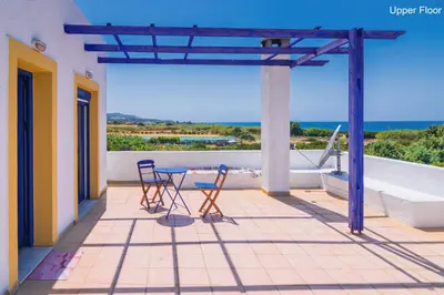 a patio with two chairs and a table on a balcony at Villa Marqua in Kalavárda