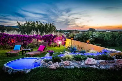 a backyard with two chairs and a rock garden at Villa Marqua in Kalavárda