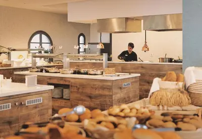 a person standing in a kitchen in a restaurant at Leonardo Kolymbia Resort Rhodes in Kolimbia