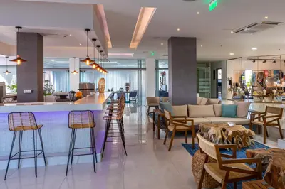 a lobby with a bar with chairs and a couch at Leonardo Kolymbia Resort Rhodes in Kolimbia