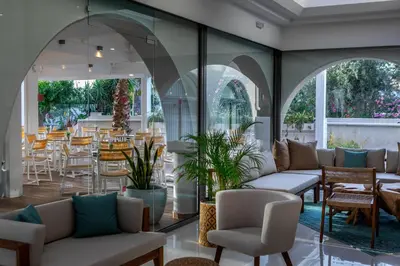 a lobby with couches and tables and chairs at Leonardo Kolymbia Resort Rhodes in Kolimbia