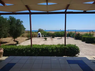 a view of a patio with an umbrella and the ocean at Afantou beach house in Kolimbia