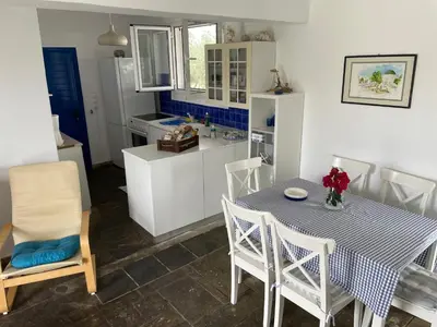 a kitchen with a table and a table and chairs at Afantou beach house in Kolimbia