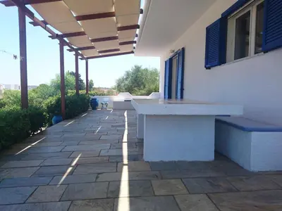 a patio with a table and benches on a building at Afantou beach house in Kolimbia