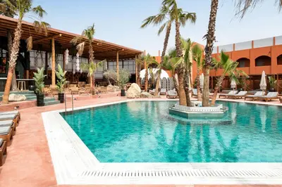 a swimming pool with palm trees in a hotel at Venezia Resort Hotel & Spa in Faliraki