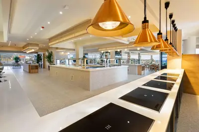 a restaurant with a bar in a lobby with lights at Venezia Resort Hotel & Spa in Faliraki