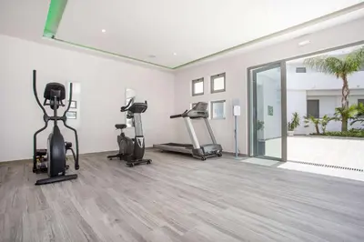 a gym with treadmills and ellipticals in a room at Venezia Resort Hotel & Spa in Faliraki