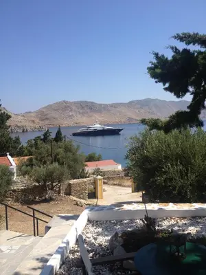 a large boat in the water with a cruise ship at Panorama Thea in Symi