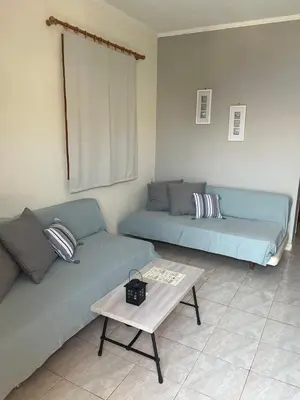 a living room with two blue couches and a table at Panorama Thea in Symi
