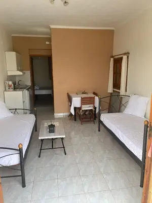 a room with two beds and a table in it at Panorama Thea in Symi