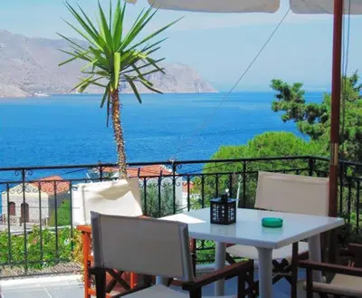 a table and chairs with a view of the ocean at Panorama Thea in Symi