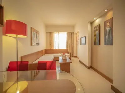 a living room with a glass table and red chairs at Sunshine Rhodes in Ialyssos
