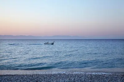 two people are in a boat in the ocean at Sunshine Rhodes in Ialyssos