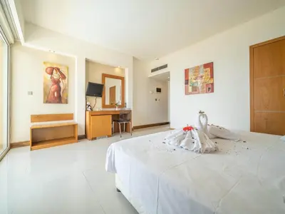 a large white bedroom with a bed and a table at Sunshine Rhodes in Ialyssos