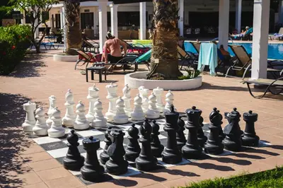 a giant chessboard on a sidewalk next to a pool at Pefkos Village Resort in Pefki Rhodes