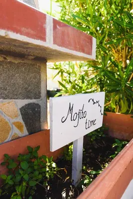 a sign that says metro time in a garden at Pefkos Village Resort in Pefki Rhodes