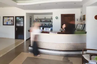 a woman is standing behind a counter in a restaurant at Pefkos Village Resort in Pefki Rhodes