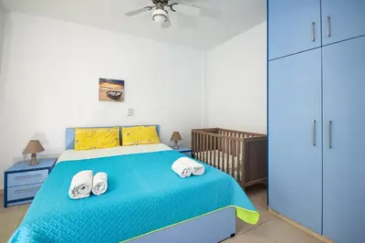 a bedroom with a blue bed with towels on it at Salora Studio-Apartments in Archangelos