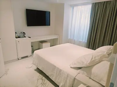 a bedroom with a bed and a flat screen tv at Ibiscus Hotel in Rhodes Town