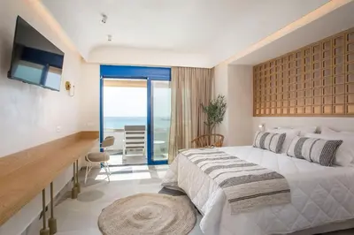 a bedroom with a bed and a desk and a balcony at Dimitra Boutique Rooms in Faliraki
