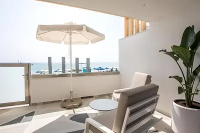 a living room with a chair and a table at Dimitra Boutique Rooms in Faliraki