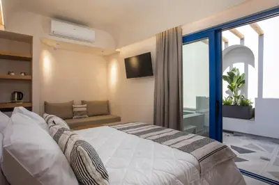 a bedroom with a bed and a couch and a window at Dimitra Boutique Rooms in Faliraki
