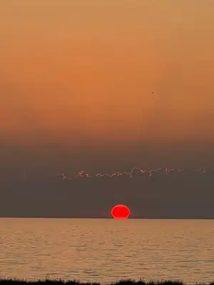 a red frisbee in the ocean at sunset at Nautilus Beach House in Paradeísion