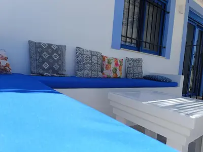 a bedroom with a blue and white bed and windows at Nautilus Beach House in Paradeísion