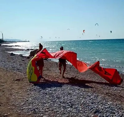 three people walking on the beach with kites at Nautilus Beach House in Paradeísion