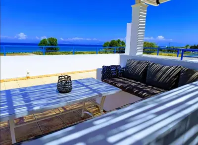 a couch and a table on a balcony with the ocean at Nautilus Beach House in Paradeísion