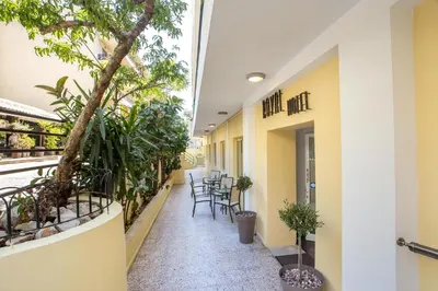 a corridor of a building with chairs and plants at Royal Aparthotel City Centre in Rhodes Town