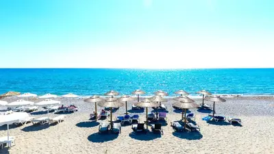 a group of chairs and umbrellas on a beach at Katikies Studios & Apartments in Lardos