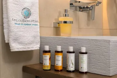 four bottles of essential oils sitting on a shelf in a bathroom at Lindos Shore Junior Suite in Líndos