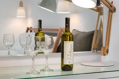 two bottles of wine sitting on a counter with glasses at Lindos Shore Junior Suite in Líndos