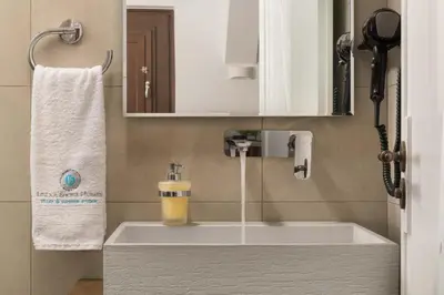 a bathroom with a bath tub with a sink at Lindos Shore Junior Suite in Líndos