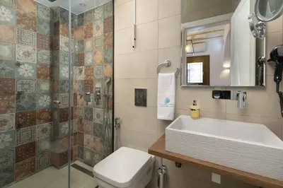a bathroom with a sink and a toilet and a shower at Lindos Shore Junior Suite in Líndos